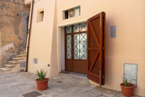 a door to a building with two potted plants at Appartamento Moderno Capoliveri in Capoliveri