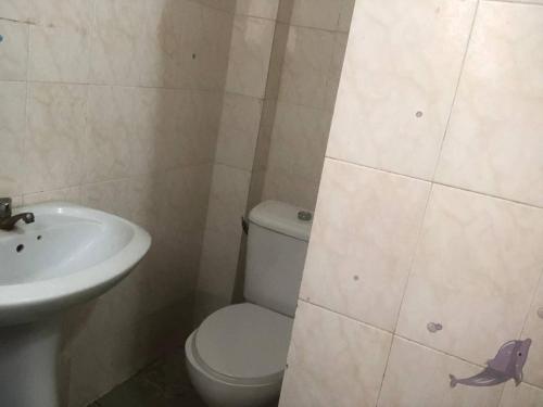 La salle de bains est pourvue de toilettes et d'un lavabo. dans l'établissement Chambre Securisée centre Dakar, à Dakar