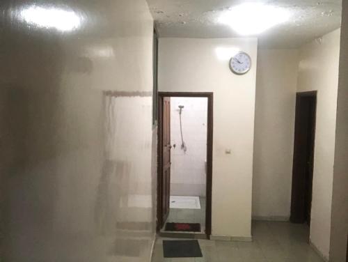 une chambre avec une horloge sur le mur et une porte dans l'établissement Chambre Securisée centre Dakar, à Dakar