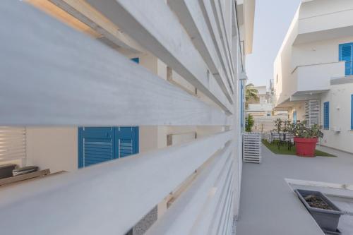 an external view of a white building with blue doors at La Scala Suite in Realmonte