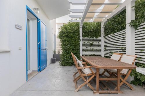 a wooden table and chairs on a patio at La Scala Suite in Realmonte
