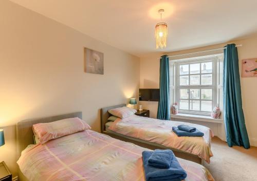 a bedroom with two beds and a window at Vale View in Glanton
