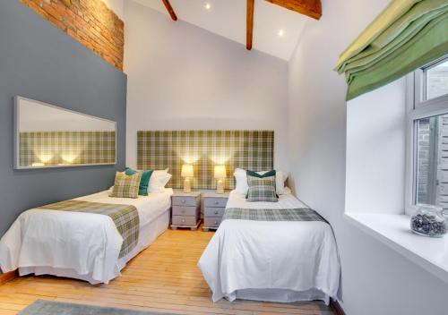 a bedroom with two beds and a mirror at Boca Chica Cottage in Cambois