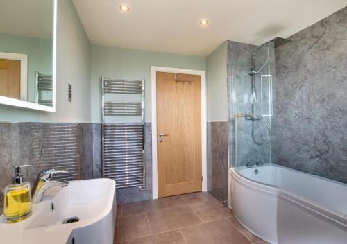 uma casa de banho com um lavatório, uma banheira e um chuveiro em 4 Brindles Manse em North Sunderland