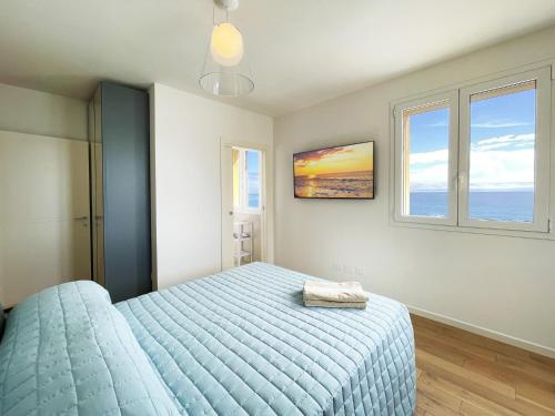 a bedroom with a blue bed and two windows at Gli Scogli Luxury Residence Hotel in Chiavari