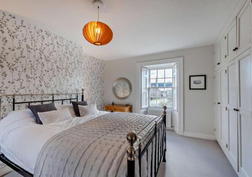 a bedroom with a large bed and a window at Glebe Farmhouse in Ellingham