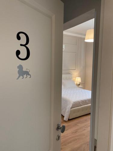 a bedroom with a bed and a door with a number on it at FOUR LIONS VILLA GUESTHOUSE in Pisa