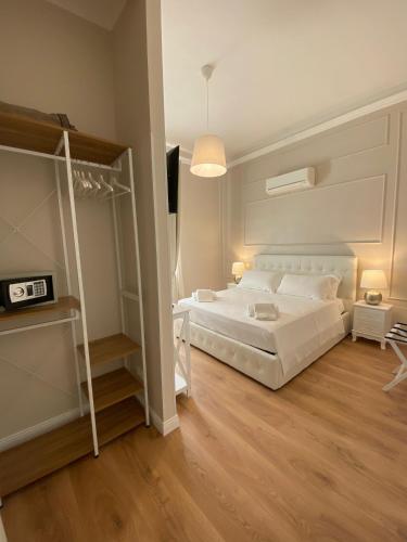 a bedroom with a large white bed and wooden floors at FOUR LIONS VILLA GUESTHOUSE in Pisa