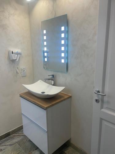 a bathroom with a white sink and a mirror at Apartament 1 Lalelelor in Năsăud