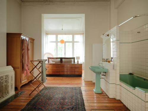 a bathroom with a green sink and a tub at Charming and spacious house with leafy private garden close to historical center of Brussels in Brussels