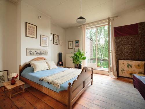 a bedroom with a bed and a large window at Charming and spacious house with leafy private garden close to historical center of Brussels in Brussels