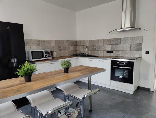 Il comprend une cuisine avec une table et des chaises en bois. dans l'établissement Le Purple, appartement de standing en hypercentre, à Sarreguemines