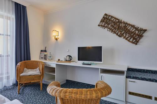 a room with a desk with a computer and two chairs at Hotel Lindenhof in Kellberg