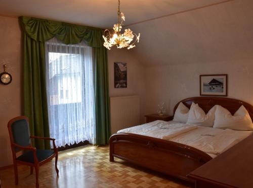 1 dormitorio con cama y lámpara de araña en NaturparkResort Haus Geigenkogel en Sankt Gallen