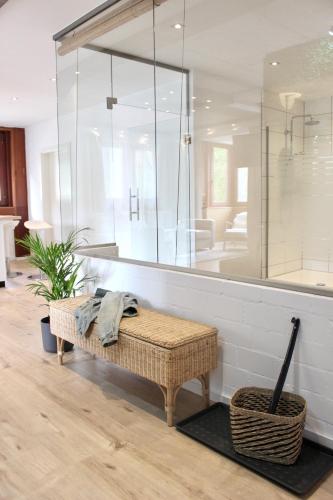 a large glass shower with a bench in a room at Vier Sind Hier Apartments in Rottweil