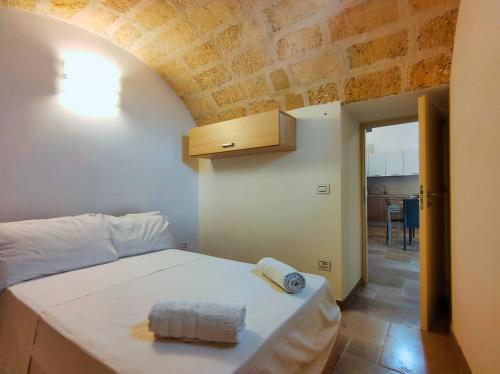 ein Schlafzimmer mit einem weißen Bett und einer Holzdecke in der Unterkunft La Casa della Zia in Depressa
