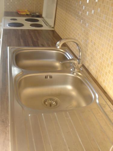 a stainless steel sink in a kitchen with a stove at Neapolis Apartments in Palaiochóra