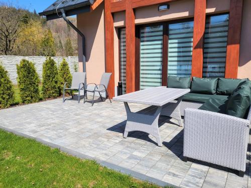 a patio with a couch and a table and chairs at RIVER REST - ADULTS ONLY in Świeradów-Zdrój