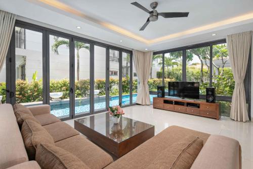 a living room with a couch and a tv at Danang Ocean Resort & Spa Non Nuoc Beach Villas in Da Nang