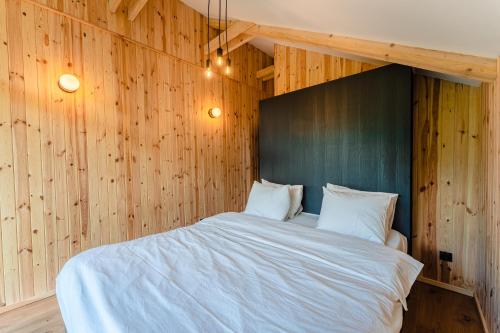 a bedroom with a large bed with wooden walls at Vila ZIA in Teşila