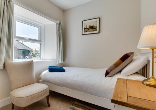 a bedroom with a bed and a chair and a window at Old Mill Branton in Glanton