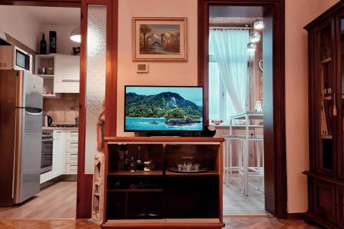 a kitchen with a flat screen tv on a entertainment center at Casa degli Ulivi 19 in Faedis