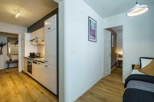 a small apartment with white walls and a kitchen at Heart of Interlaken Apartments in Interlaken