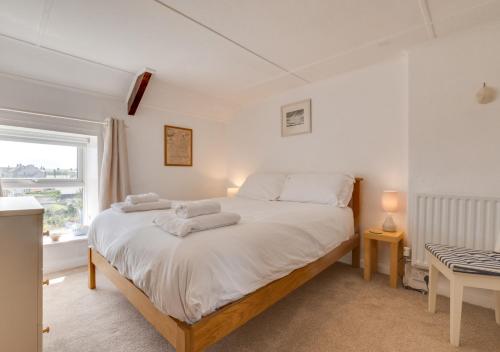 a bedroom with a bed with towels on it at Castle Point Cottage Craster in Craster