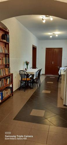 a room with a table and chairs and a book shelf at Edukativ Szállás in Skorenovac