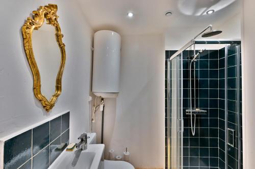 La salle de bains est pourvue d'un lavabo et d'une douche avec un miroir. dans l'établissement Logis Cointereau, à Baugé