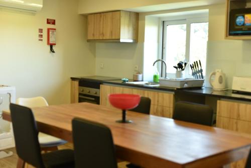 a kitchen with a wooden table and a red chair at CASA DA `VÓ MICAS in Cardeal