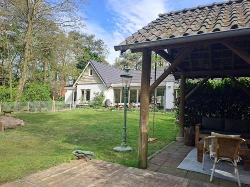 a pergola with a lamp in the yard of a house at Garden studio in Rijsbergen