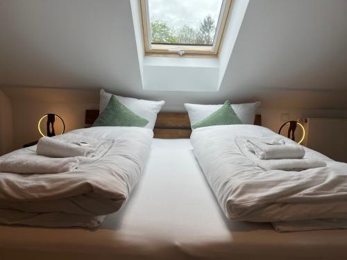 2 Einzelbetten in einem Zimmer mit Fenster in der Unterkunft Alpen Lodge in Osterhofen - Berge, Ruhe & Natur in Bayrischzell