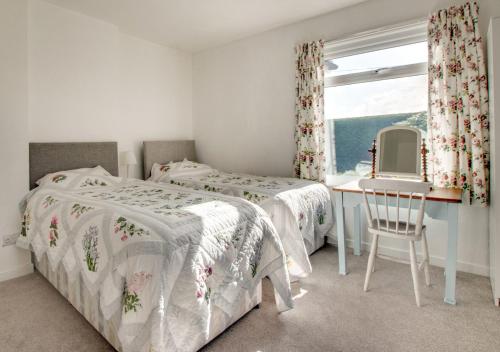 1 dormitorio con 2 camas, escritorio y ventana en Bolams Lodge, en Ancroft