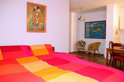 een slaapkamer met een kleurrijk bed en een eetkamer bij CaseOspitali - Casatita, un nido x2 vicino Università di Trento in Trento