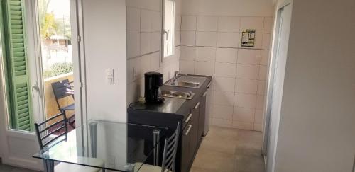 een kleine keuken met een wastafel en een fornuis bij Studio dans résidence avec piscine in Calvi