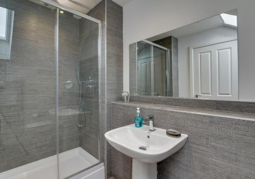 a bathroom with a sink and a glass shower at Coastal Retreat in Amble