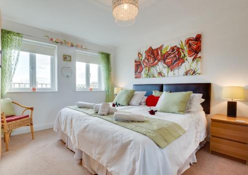 a bedroom with a large bed and two windows at Twin Palms No 2 in North Sunderland
