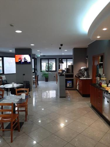 a large kitchen and dining room with tables and chairs at Hotel Alabama by ALEhotels in Rimini