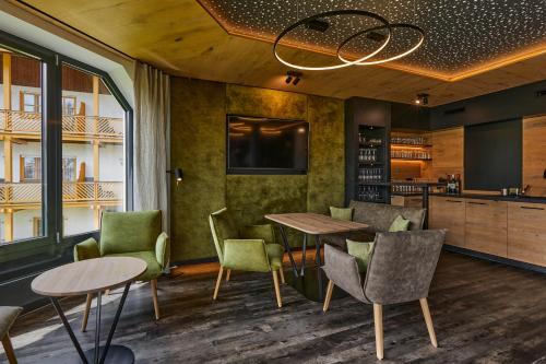a restaurant with tables and chairs and a tv at Hotel Lindenhof in Kellberg