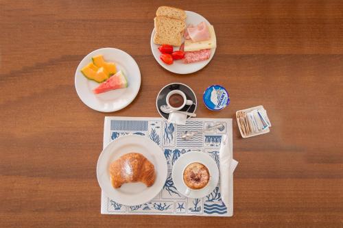 two plates of food on a table with breakfast foods at Hotel Casa Adolfo Ischia in Ischia