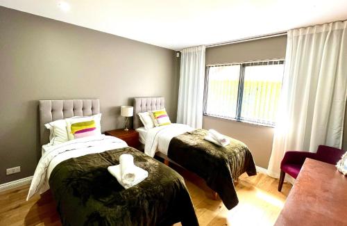 a bedroom with two beds and a window at Fairways Villa Newcastle in Newcastle