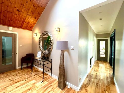 a living room with a mirror and a lamp at Fairways Villa Newcastle in Newcastle