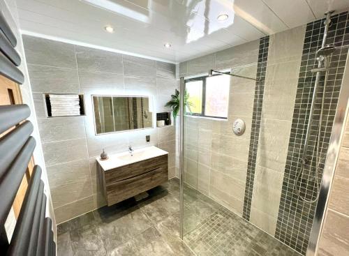 a bathroom with a sink and a glass shower at Fairways Villa Newcastle in Newcastle