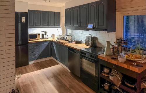 - une cuisine avec des armoires noires et un comptoir avec un bol de fruits dans l'établissement 1 Bedroom Cozy Home In rkelljunga, à Orkelljunga