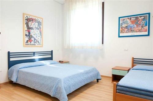 1 dormitorio con 2 camas y ventana en MiMa Hostel Moorea, en Milano Marittima