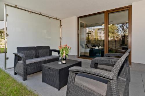 a patio with chairs and a couch and a table at BlueApart Apartamenty Na Klifie in Władysławowo