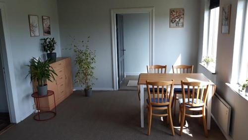 a dining room with a table and chairs in a room at Landstedet in Gram