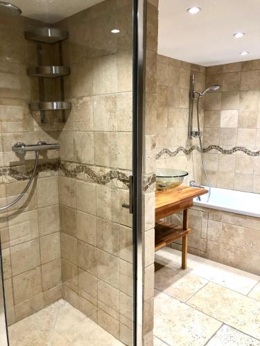 une douche avec une porte vitrée dans une salle de bain dans l'établissement Magnifique LOFT Appartement Chalet Climatisé Buttes Chaumont, à Paris