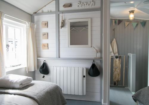 a bedroom with a bed and a radiator and a window at Molly Muppet in Mousehole